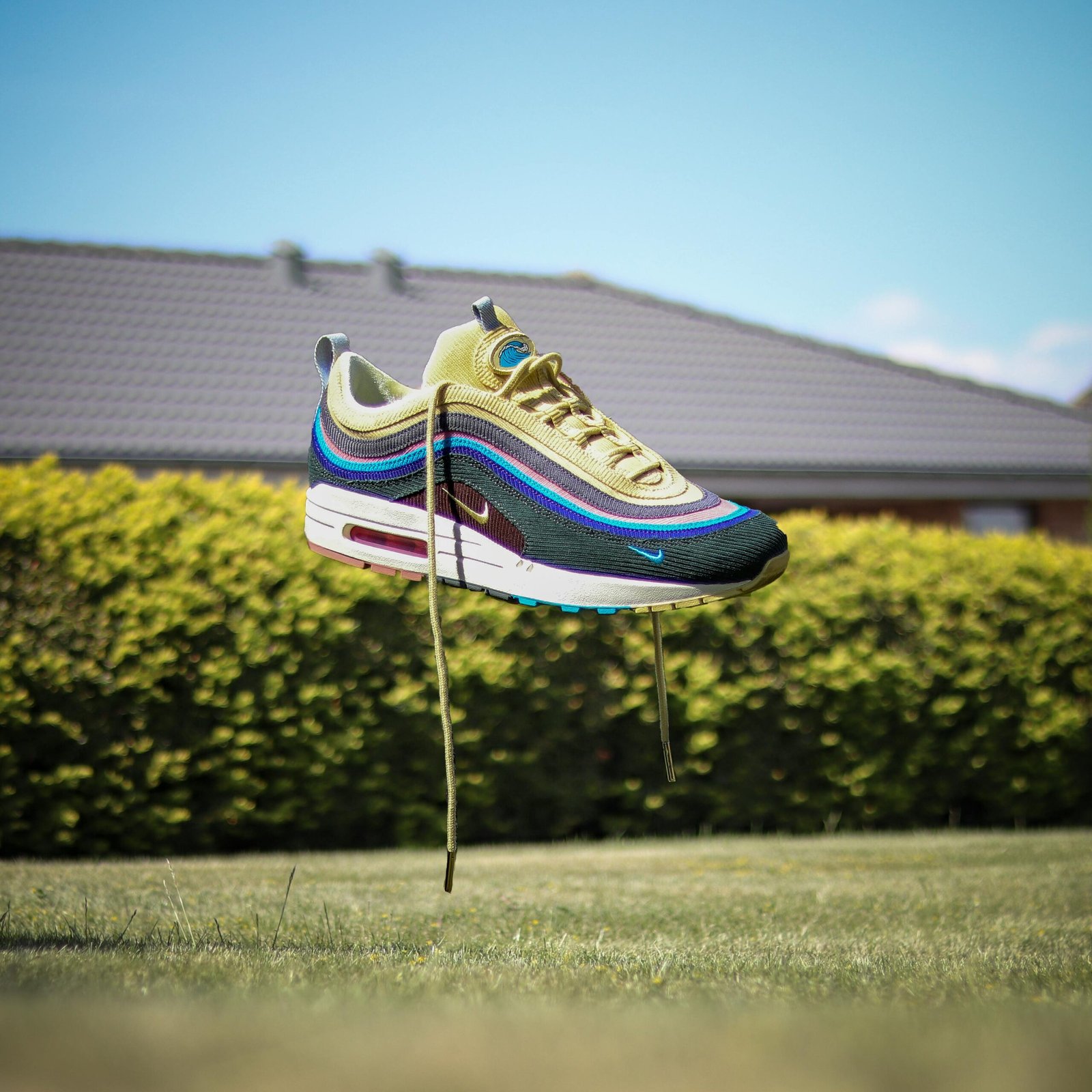 Nike sneaker floating above grass in a sunny Danish garden.